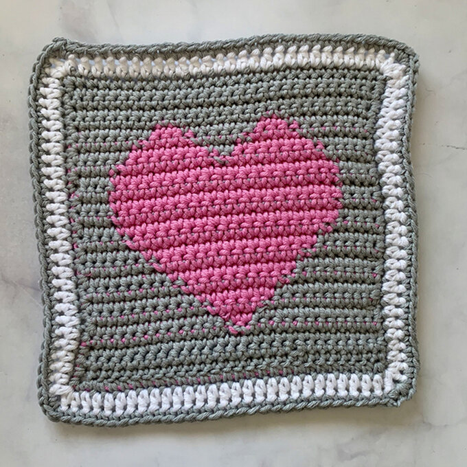 Solid granny square with a heart motif pattern