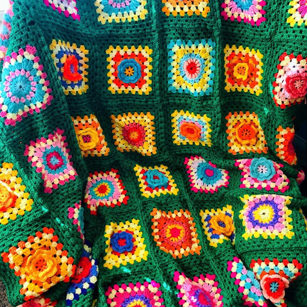 green crochet blanket with flower squares